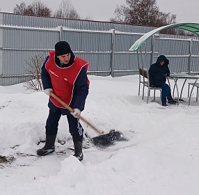 Инклюзивные волонтеры расчищают снег на территории учреждения, посыпают все дорожки песком, чтобы никто не поскользнулся и не получил травму.